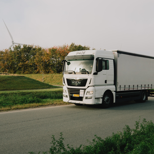 TEC Lastbil på landevej omgivet af grønne områder – relevant for Klimaerhvervsskoler og undervisning i C/E lastbilkørekort